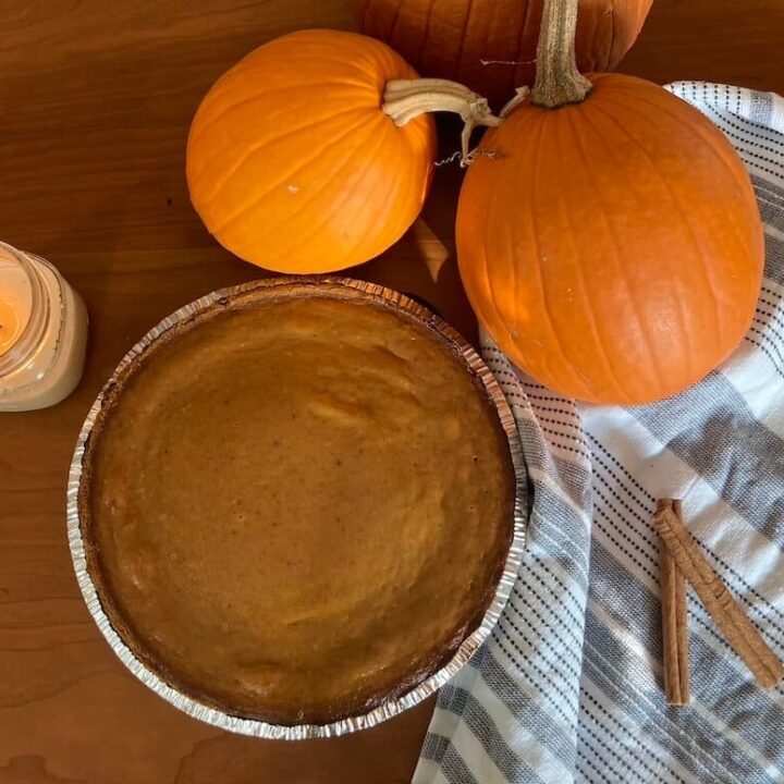 a pumpkin pie table setting with pumpkins a candle and cinnamon sticks