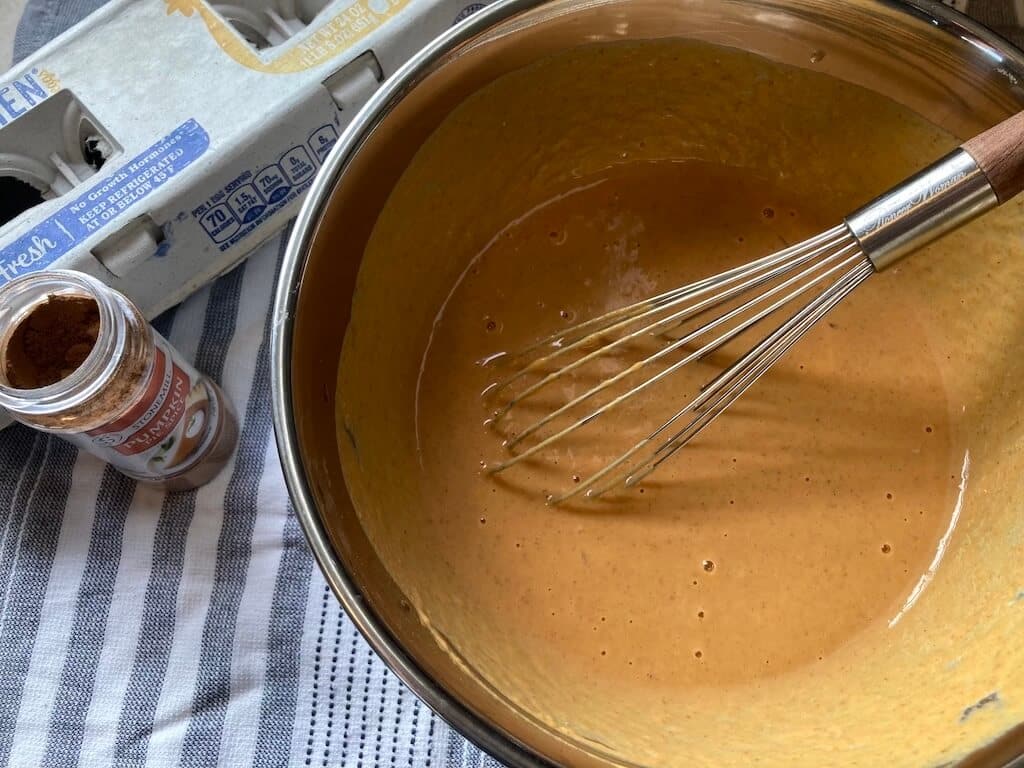 pumpkin pie ingredients whisked together in mixing bowl