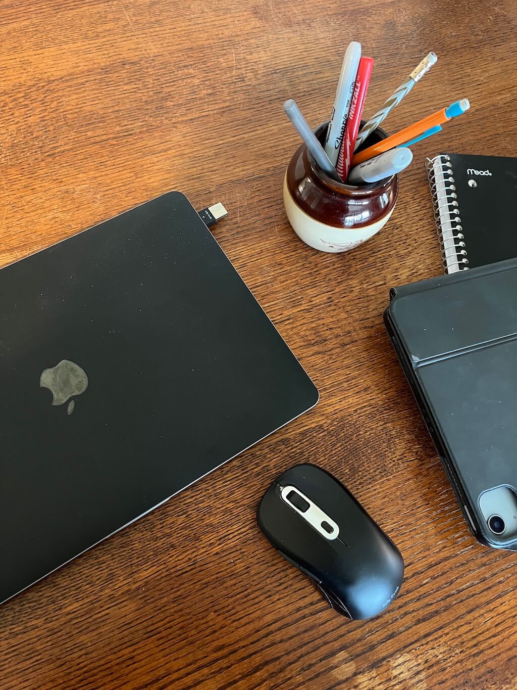computer ipad notebook and pens on a desk