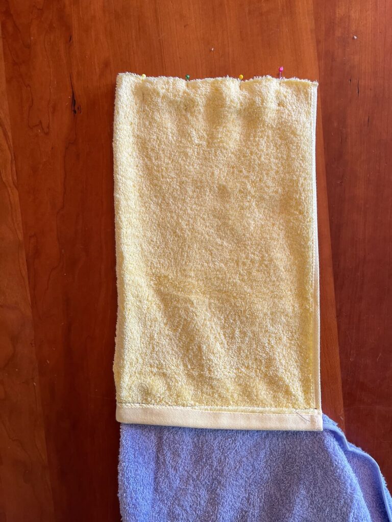 top cut edges of hand towel pinned together
