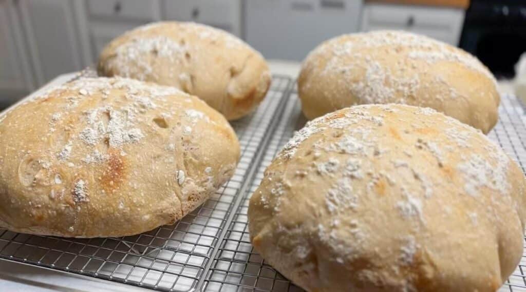 four sourdough loaves cooling on counter