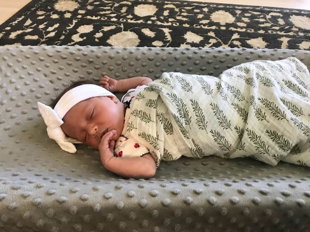 baby girl sleeping on changing pad