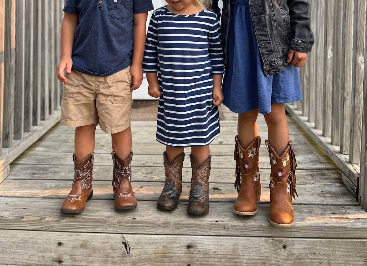 three small children on porch in church outfits