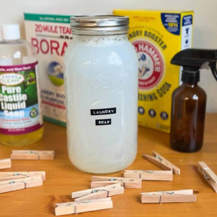 glass jar of homemade liquid laundry detergent with ingredients and clothespins