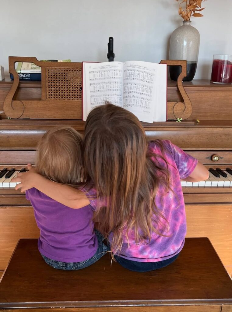 young sisters playing piano together