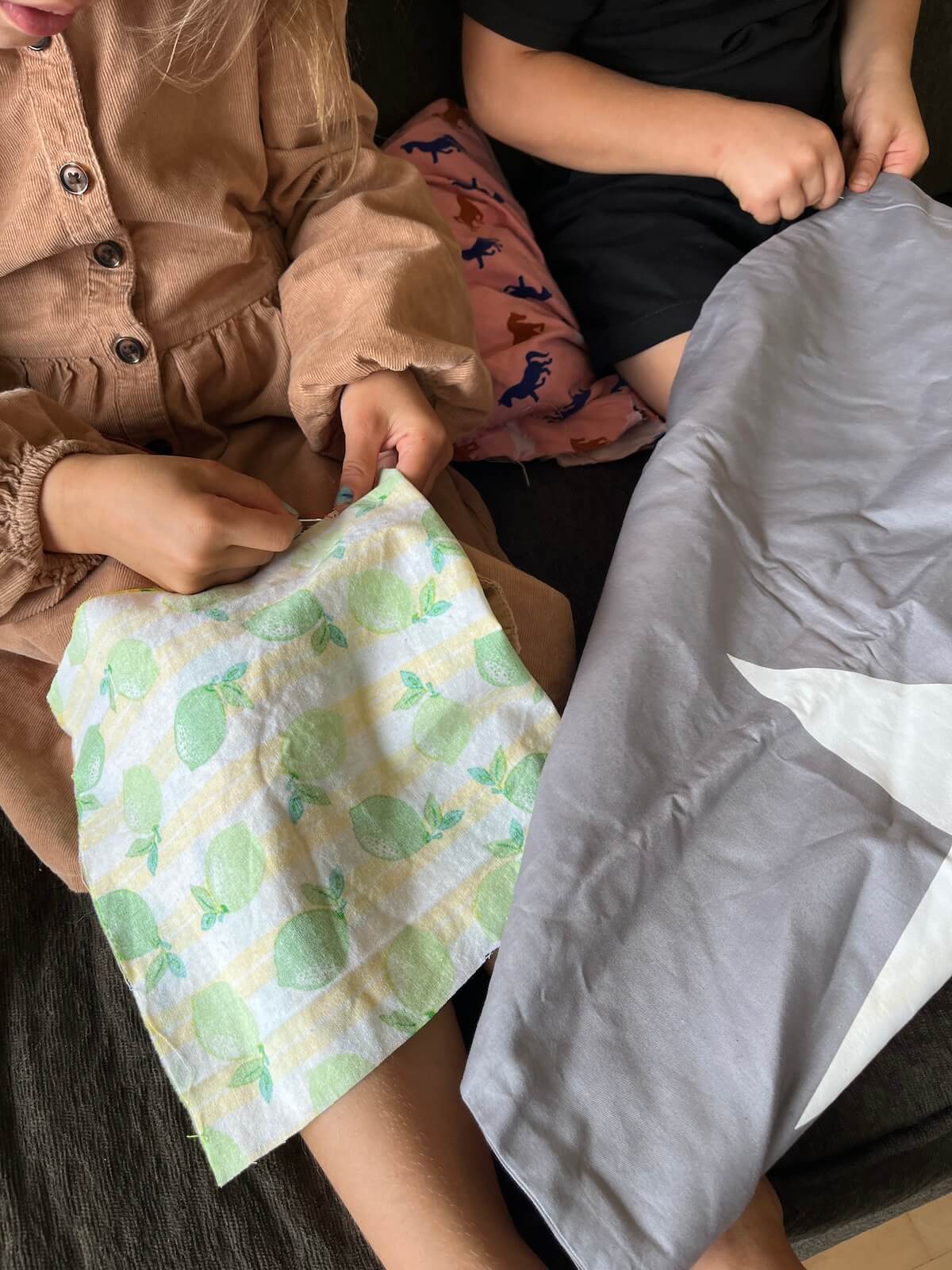young girl and young boy hand sewing on couch