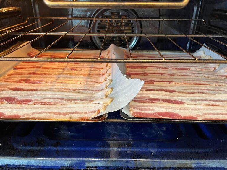 pans of bacon slices inside oven cooking